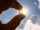 hand holding vitamin d pill in sunshine