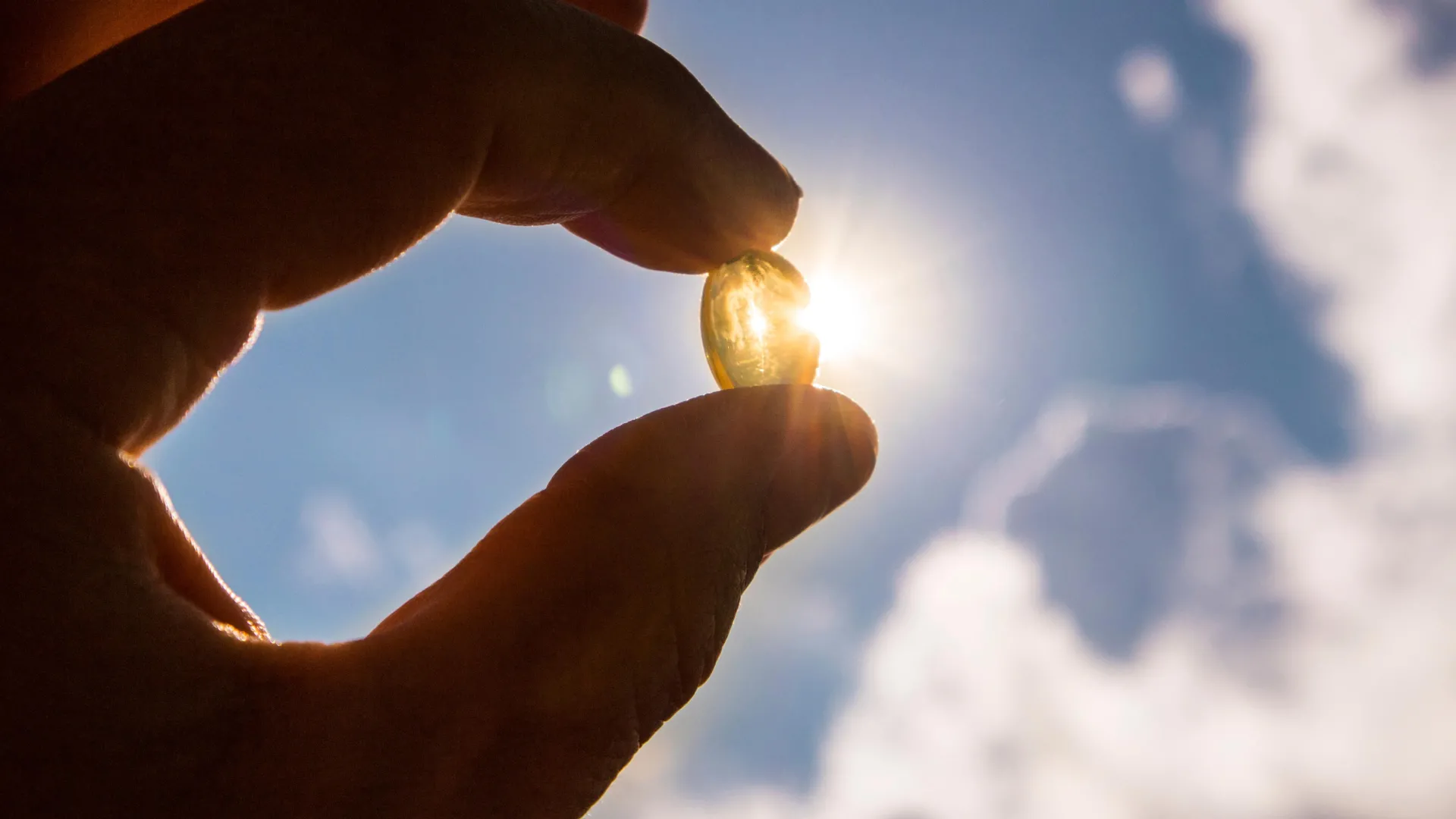 hand holding vitamin d pill in sunshine